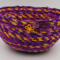 This shows the detail of the front of the basket. There is one large golden yellow flower button with 2 smaller purple ones.