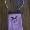 Pink vinyl crossbody bag with embroidered pig design wearing a floral bandana. White zipper top and strap