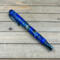 Blue titanium rollerball pen made with cast flowers in clear blue resin 