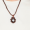 Orange Petal Bloom Necklace featuring handwoven burnt orange and black glass beads in a geometric floral pattern.