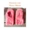A pair of handmade coral pink mittens for kids ages 8 to 10 years old.