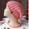 A hand knit pink wool beanie with a ribbing stretchy stitch pattern. For children and preteens ages 10, 11, 12, 13, 14.