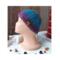 A side view of a handmade baby hat in a blue & purple wool blend yarn. Great for winter holiday gifting for newborn babies 0 to 12 months.