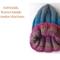 A side view of a handmade baby hat in a blue & purple wool blend yarn. Great for winter holiday gifting for newborn babies 0 to 12 months.