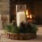 Rustic wood slice candle centerpiece with pinecones displayed near fireplace, cozy winter farmhouse decor