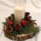Handmade rustic wood slice candle centerpiece with pine greenery, pinecones, red heart accents, and glass hurricane candle holder