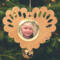 Wooden heart-shaped ornament with scalloped edges and an oak grain finish, featuring a removable round gold frame that holds a photo of a smiling blonde child.
