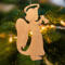 A handmade wooden Christmas ornament in the shape of a cheerful angel, featuring a halo, wings, and a raised arm ringing a bell, hand-cut from solid hardwood and finished with clear shellac.