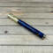 Gold rollerball pen with blue resin and pinecones 