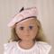 Blonde 18 inch doll wearing a pink beret/hat with black trimmings