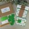 A St. Patty's Day card making kit with clovers, gold ribbons, stamped sentiments and glitter mats to make 6 greeting cards.