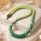 Verdant Fade Kumihimo Necklace styled in an elegant flat lay, green beaded Kumihimo necklace arranged with decorative accents