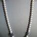 On either side of the focal point is 23 glass pearl beads, for a total of 50 glass pearls in the entire necklace.