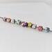 Nine small handmade copper enameled beads of various rainbow colors torch fired