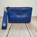 front view of a  blue marbled faux leather makeup bag with gunmetal hardware and a wristlet strap.