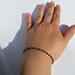 Person models the bracelet on their wrist.  Photo taken showing the beaded bracelet from the top side of the arm, wrist, and hand.