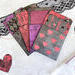 Black, red, and purple library pockets with heart and striped patterns. 
