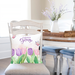 Welcome spring pillow cover displayed on a pillow on a dining chair