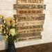 This picture shows an extra large piece of lake house wall decor. It is a collection of lake life rules on reclaimed boards. The decorative lettering is wood-burned by hand.