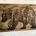 This is a large wood statement piece. It features a wood-burned bear that has a forest scene drawn inside of it. It is three feet wide. 