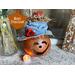 This image shows a pumpkin gourd named Peaches. She has a handmade hat and a battery-operated candle to light up her smile. 