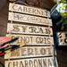A picture of me making this wine sign. I wood-burned the names of wine onto boards and then tied them together with twine. 