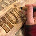 This image shows me wood burning a decorative lettering style on reclaimed wood.