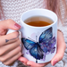 Butterfly and lilac mug in woman's hands