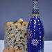 Hand painted blue bottle with various dot art/mandala designs around the entire bottle