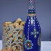 Hand painted blue bottle with various dot art/mandala designs around the entire bottle