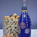 Hand painted blue bottle with various dot art/mandala designs around the entire bottle