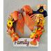 A 13" grapevine Fall and Thanksgiving wreath.  Handcrafted with  multi colored leave, scarescrow,  small corn on the cob and pumpkins.  White plaque with FAMILY written in brown paint.