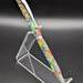 Picture of the right side of a pen in an acrylic holder. The pen is matte with rainbow colors marbled across it and matte pearl pen pieces.