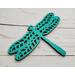 A bright Aqua painted wooden dragonfly on a faux wood background.