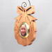 A handmade wood photo ornament featuring a hand-cut design and a customizable photo insert.