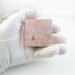 Handmade tiny copper trinket box with purple and green vine-rose pattern on lid and pink tourmaline october  gemstone cabochon shown in my gloved hand for size comparison