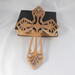 This Ten-Inch Rustic Fretwork Christian Cross Wall Hanging Art is handcrafted from reclaimed wood. Its intricate fretwork design adds unique texture and character, blending rustic charm with elegant design. It is a perfect focal point for any room.