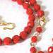 Close-up view of red glass beads and gold plated clasp.