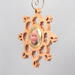 A handmade wood photo ornament featuring a hand-cut design and a customizable photo insert.