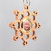 A handmade wood photo ornament featuring a hand-cut design and a customizable photo insert.