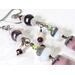 Close-up view of gemstone and crystal dangling earrings.