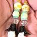 Long floral dangle earrings, with black brass petals, white glass, and yellow opals.