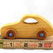 Handmade wooden toy car modeled after the classic 1957 Bug with an amber shellac finish and metallic sapphire blue trim from My Play Pal Collection.