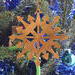 Handmade Snowflake Style Christmas Tree Ornament crafted from reclaimed wood, lightly sanded, and finished with clear shellac. A rustic holiday decor choice, perfect for gifting. Upcycled materials contribute to its environmentally friendly design.