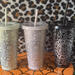 A 24oz matte cold cup in each color available: Black, Grey, and Mint.  They all feature the Spooky Doodle background in silver vinyl. Leopard print background.
