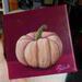 Photo of small square canvas painting of peach colored pumpkin with a raspberry pink background