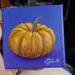 Photo of small square canvas painting of orange pumpkin with purple blue background