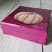 Photo of sideview of small square canvas painting of peach colored pumpkin with a raspberry pink background