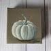 Photo of small square canvas painting of white pumpkin with a light brown background