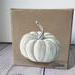 Photo of small square canvas painting of white pumpkin with a light brown background